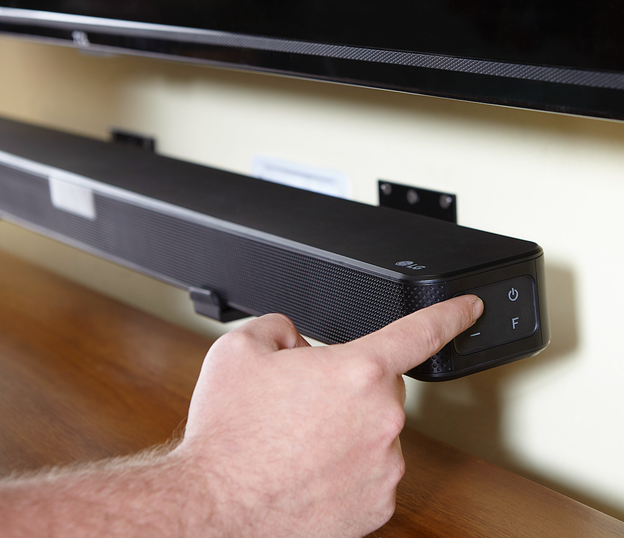 soundbar mounted to wall beneath tv